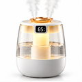 White and gold humidifier with clear tank, two mist outlets and warm amber light